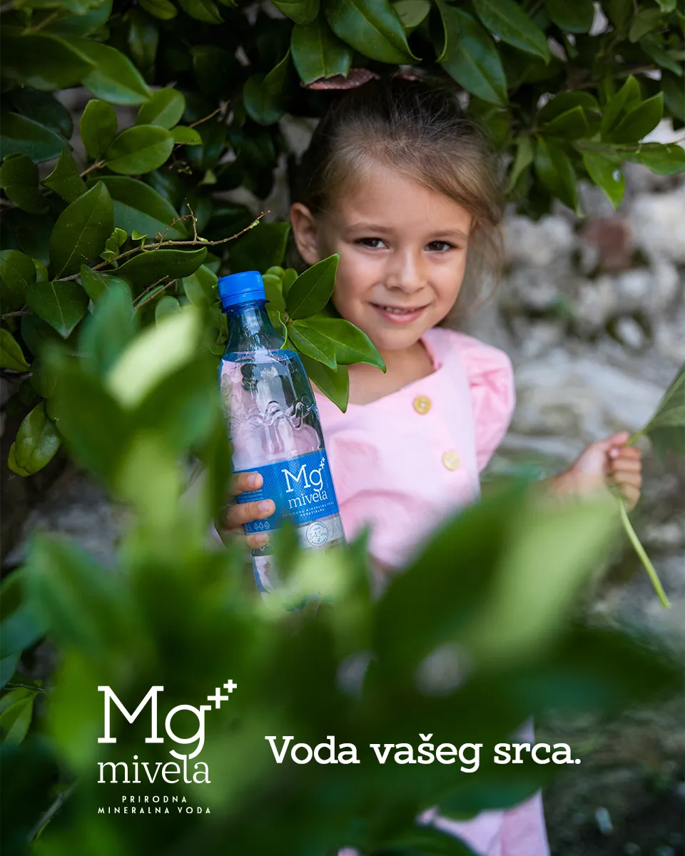 Fotografija devojčice predškolskog uzrasta u prirodi sa flašicom plave Mg Mivela vode