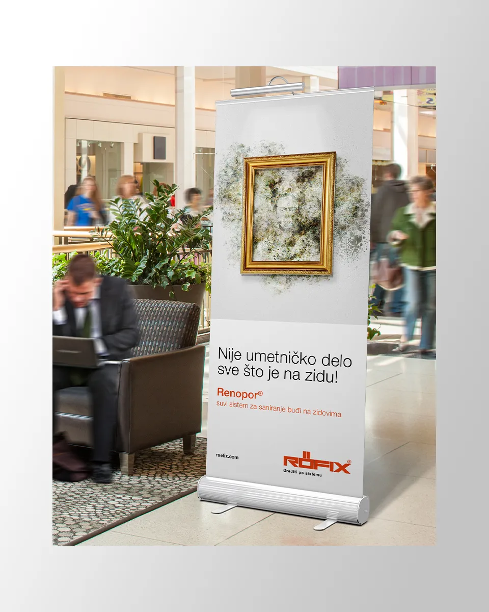 Rollup baner u poslovnom prostoru sa reklamom za Rofix sistem protiv buđi i slogan Nije umetničko delo sve što je na zidu